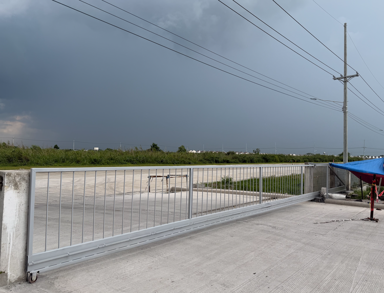 The installed 15-meter trackless cantilever gate in silver aluminum on site