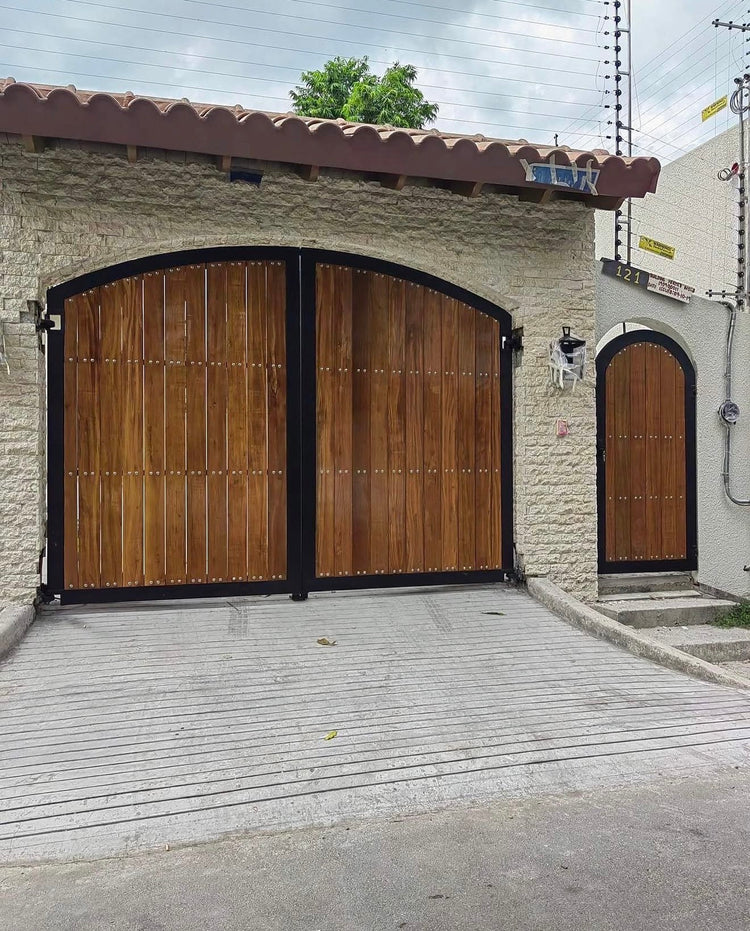 Finished Mediterranean-style arched gate in steel and Yakal wood, with matching pedestrian door